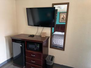 a flat screen tv on the corner of a room at Encore Motel in Farmington