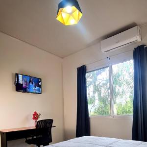 a bedroom with a bed and a tv and a window at COCOVIEW Hotel in Valle de Ángeles