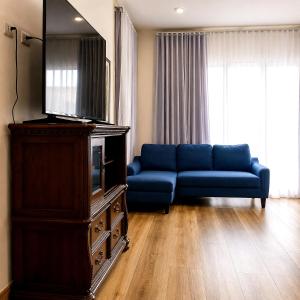 a living room with a blue couch and a tv at COCOVIEW Hotel in Valle de Ángeles