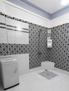 a bathroom with a toilet and a tile wall at Appt Spacieux, Confortable, Calme, et Lumineux, Proche de la Plage avc Fibre Optique in Safi +5 photos