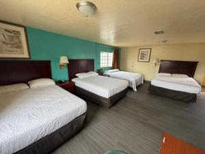 a hotel room with two beds and blue walls at Encore Motel in Farmington