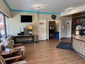 a lobby with a waiting area with chairs and a tv at Travelodge by Wyndham Reno in Reno