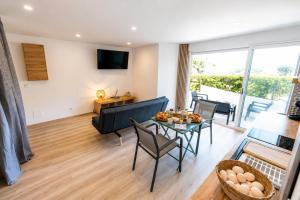 a living room with a couch and a table at Le Refuge Marin - Vue Mer - Accès direct Plage - Terrasse - Climatisation - Place de Parking in Leucate-Plage
