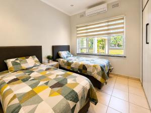 a bedroom with two beds and a window at Umhlanga La Lucia Oasis, Family Friendly Accommodation in Durban +30 photos