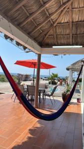 a hammock on a patio with a table and chairs at Villa Del Mar 14 in Antón Lizardo