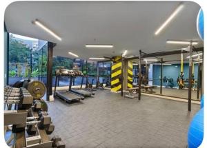 a gym with several treadmills and benches in a room at Poblado de lujo in Medellín