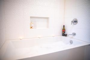 ein weißes Badezimmer mit einer Badewanne mit Waschbecken in der Unterkunft Suite Ucluelet - Romantic Couples Getaway-Sauna! in Ucluelet + 33 Fotos
