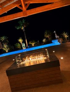 a table with a fire place in the middle of a patio at night at Luxury home private duras in Duras