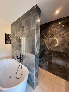 a bathroom with a white tub and a glass wall at Design-Villa mit privatem Whirlpool&Naturblick in Wellheim +12 photos