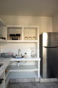 a kitchen with a sink and a refrigerator at Casa Origen in Oaxaca City