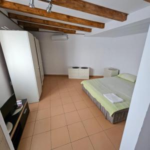 a small room with a bed and a refrigerator at Apartman Stepanović 2 in Prijevor