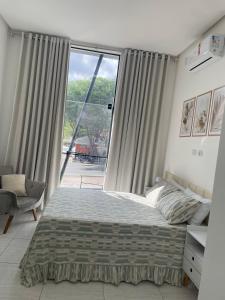 a bedroom with a bed and a large window at Pousada Imperial in Seabra