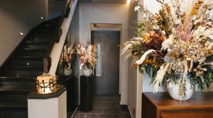 ein Flur mit Treppe und Blumen in Vasen in der Unterkunft Hippodrome Hotel in Mexiko-Stadt