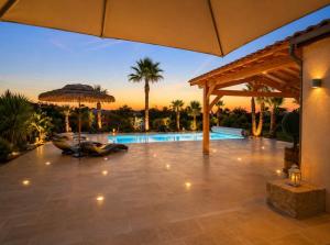 an outdoor patio with a pool and an umbrella at Luxury home private duras in Duras