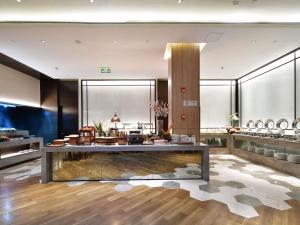 a lobby with a table in the middle of a room at Mercure Qidong Downtown in Qidong