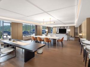 a large room with tables and chairs and a kitchen at Pullman Taizhou Shenxianju in Xianju