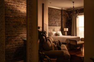 a bedroom with a bed and a brick wall at The Luxe Loft Knoxville in Knoxville