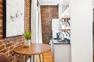 a kitchen with a wooden table and a brick wall at The Luxe Loft Knoxville in Knoxville
