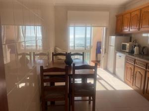a kitchen with a table and chairs with a view of the ocean at Casa do Pai in Vila Praia de Âncora