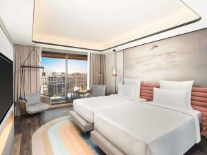 a hotel room with two beds and a balcony at Novotel Goa Panjim in Panaji