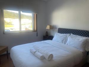 a white bed with white pillows and a window at Casa do Pai in Vila Praia de Âncora
