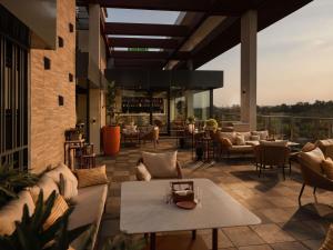 a patio with couches and tables on a building at ibis Styles Mysuru in Mysore