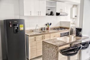 a kitchen with a refrigerator and a sink at Apartamento Paradise in Ibagué