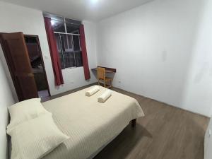a bedroom with a bed with two white towels on it at JJ Guest House Kuelap in Nuevo Tingo