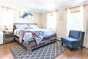 a bedroom with a bed and a blue chair at Tonel Paradise in Rosedale