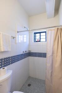 a white bathroom with a shower and a toilet at Casa Origen in Oaxaca City +76 photos