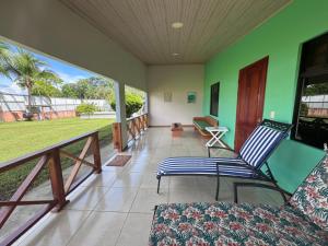 a living room with a balcony with a couch and a table at Tropical Haus CR - La Central in Puerto Jiménez