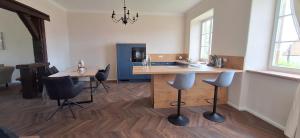 a kitchen with a counter and chairs in a room at Chateau de Gendersberg in Hanviller