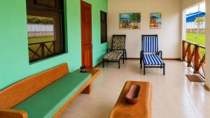 a living room with two chairs and a couch at Tropical Haus CR - La Central in Puerto Jiménez
