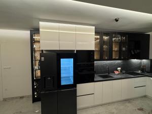 a kitchen with white cabinets and a black refrigerator at Apartment Lumos in Ljubuški