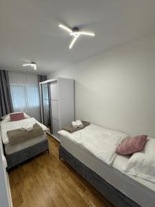 a bedroom with two beds and a ceiling fan at Apartment Lumos in Ljubuški