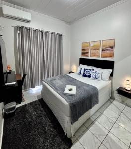 a bedroom with a large bed with blue pillows at Hospedagem Domiciliar em Lucas do Rio Verde in Lucas do Rio Verde +18 photos