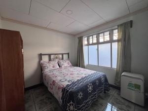 a bedroom with a bed and a large window at Tropical Haus CR - El Manglar in Puerto Jiménez