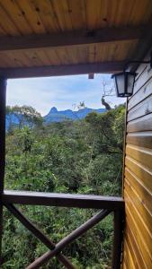 a window view of a forest with mountains in the background at Cabana Zermatt in Timbe do Sul