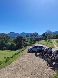 a group of bikes parked on a dirt road with a car at Cabana Zermatt in Timbe do Sul +2 photos