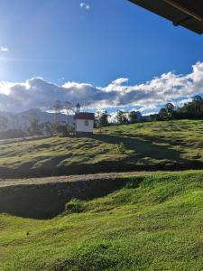 a field with a building in the middle of it at Cabana Zermatt in Timbe do Sul