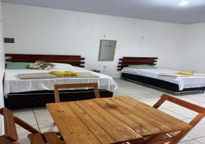 two beds in a room with a table and chairs at Margarida AP 3 in Presidente Figueiredo