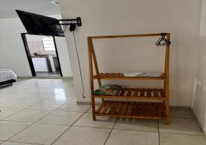 a room with a tv on a wall and a shelf at Margarida AP 3 in Presidente Figueiredo