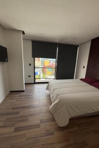 a bedroom with a large bed and a large window at Residencia familiar céntrica xalapa in Xalapa