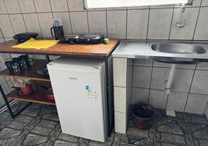 a small kitchen with a sink and a refrigerator at Margarida AP 3 in Presidente Figueiredo