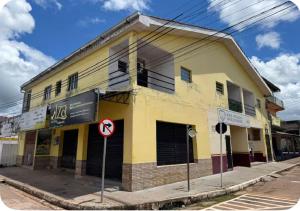 a yellow building on the corner of a street at Margarida AP 3 in Presidente Figueiredo