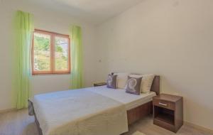 a bedroom with a large bed and a window at Apartments by the sea Metajna, Pag - 6289 in Zubovići