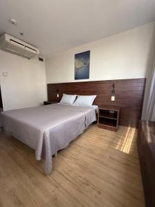 a bedroom with a large bed and a wooden floor at Flat em Taguatinga in Taguatinga