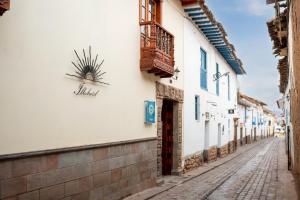 a cobblestone street in a town with a plant on the wall at Illa Hotel in Cusco