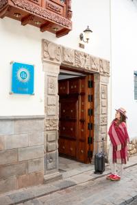 a woman standing in front of a building with a suitcase at Illa Hotel in Cusco +93 photos