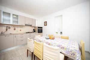 a kitchen and dining room with a table and chairs at Apartments by the sea Stara Novalja, Pag - 6301 in Stara Novalja +37 photos